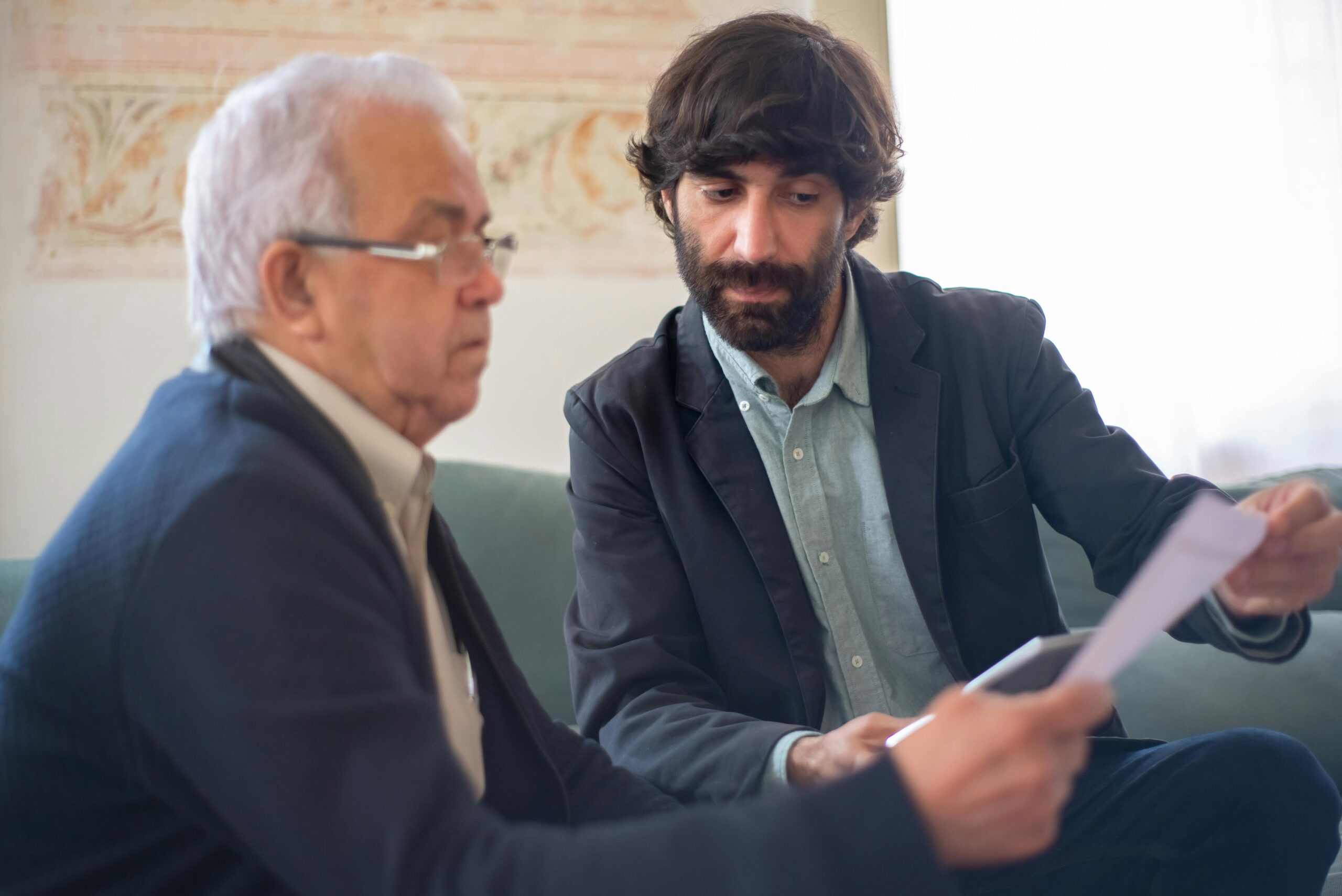 A bearded man showing a document to his client